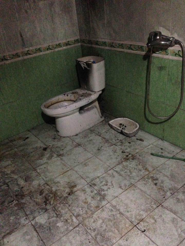 Trần và sàn nhà tắm đều đen sì. Bình chứa bồn cầu bị tung cả nắp đậy.