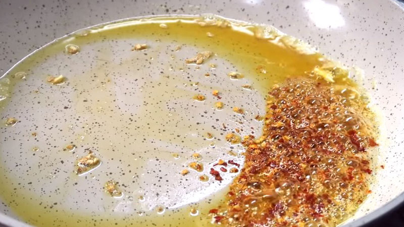 Cho bơ thực vật và chảo, đun lên cho bơ tan chảy, rồi cho tỏi vào, nếu bạn thích ăn cay thì cho bột ớt vào luôn nhé.